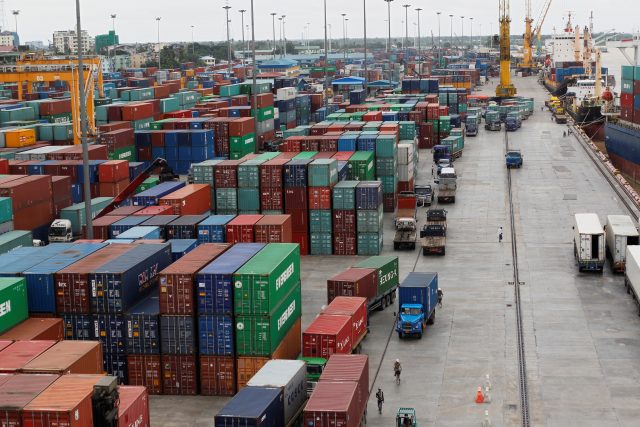 Workers are seen among the containers at Asia World port in Yangon