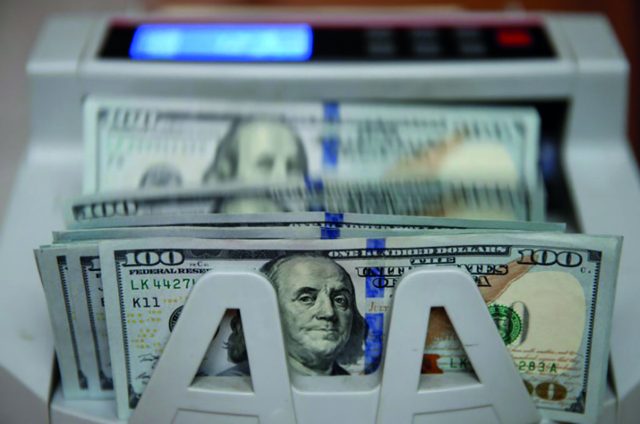 Money counter counts 100 U.S dollar banknotes in Kiev